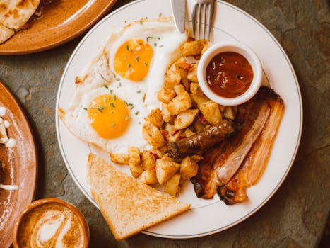 Delicious breakfast plate with sunny side up eggs, bacon, and toast.